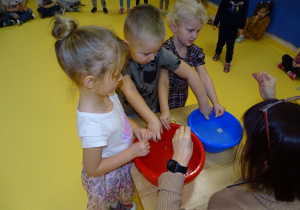 09 dzieci wkładają ręce do misek z wodą, sprawdzają miękkość wody